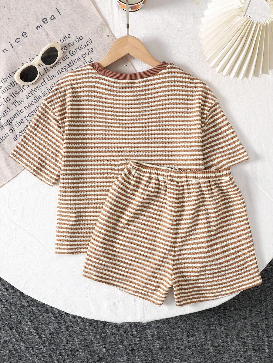 Tween girl wearing a black and white striped drop-shoulder crew neck t-shirt with bow embroidery paired with matching tie-waist shorts.
