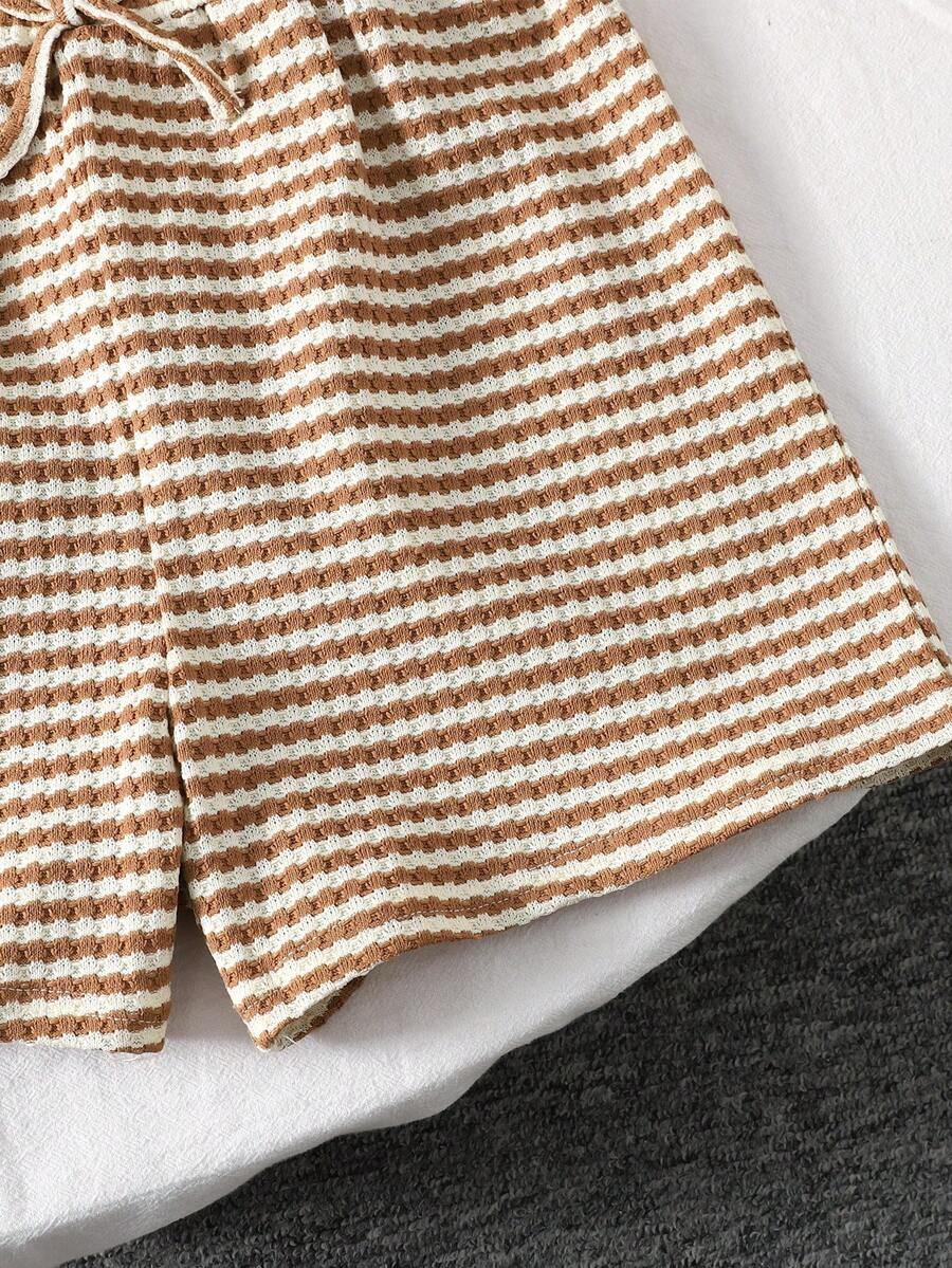 Tween girl wearing a black and white striped drop-shoulder crew neck t-shirt with bow embroidery paired with matching tie-waist shorts.