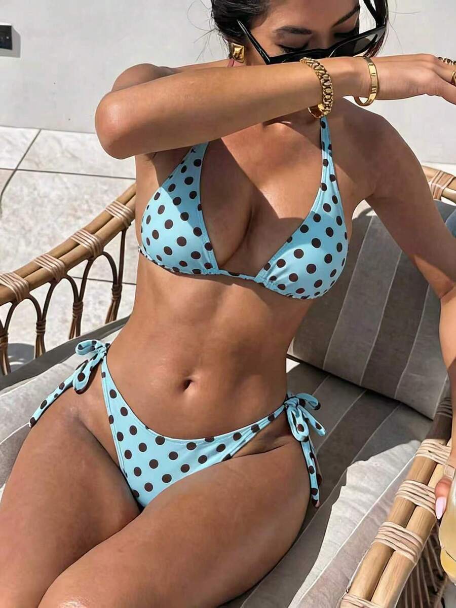 Women's polka dot two-piece bikini set featuring a backless halter top with triangle cups and matching tie-side bottoms.