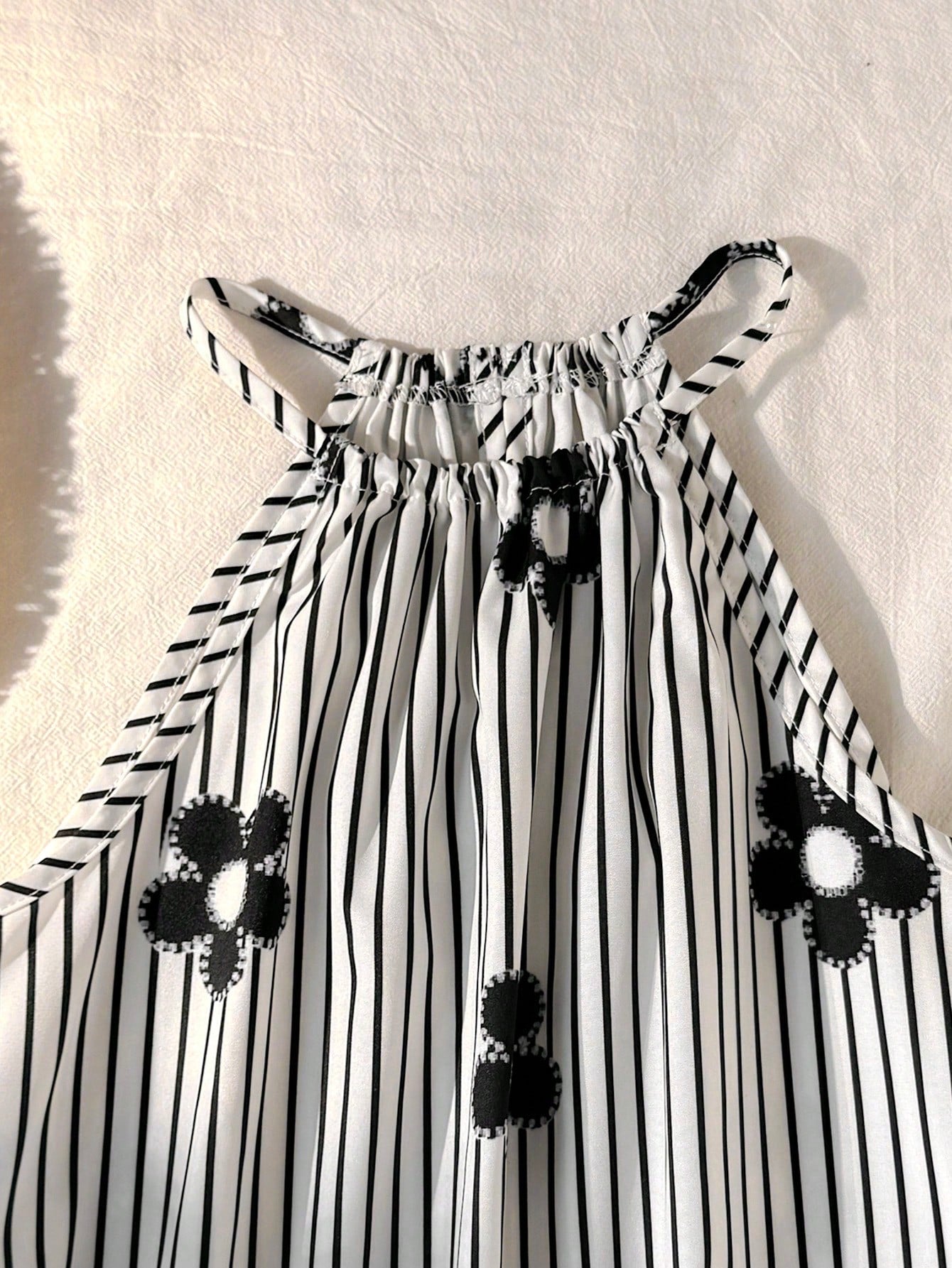 Tween girls floral print dress with halter neckline, sleeveless cold shoulder design, A-line shape, and vacation style.