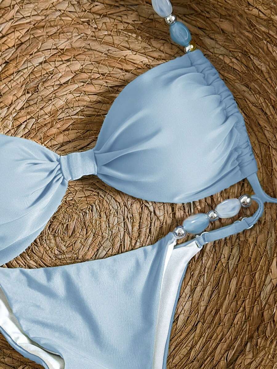 Women's green halter neck bikini set featuring color-block beaded shoulder straps, back tie detail, and high cut bottoms.