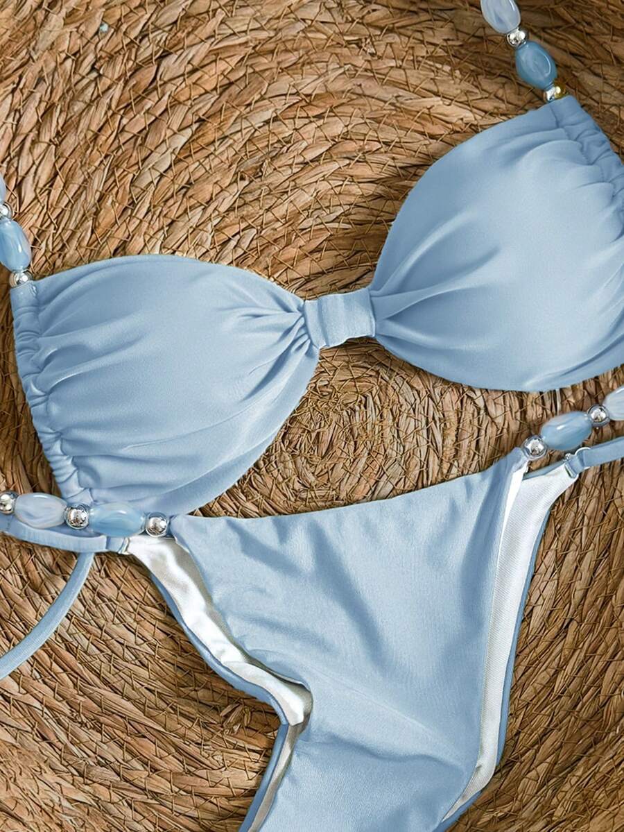 Women's green halter neck bikini set featuring color-block beaded shoulder straps, back tie detail, and high cut bottoms.