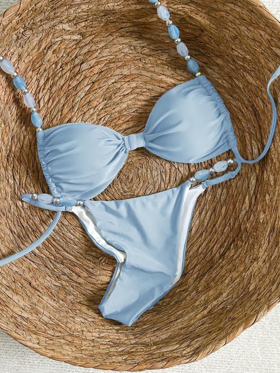 Women's green halter neck bikini set featuring color-block beaded shoulder straps, back tie detail, and high cut bottoms.