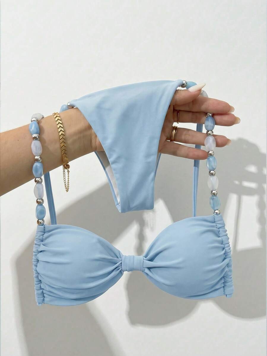 Women's green halter neck bikini set featuring color-block beaded shoulder straps, back tie detail, and high cut bottoms.