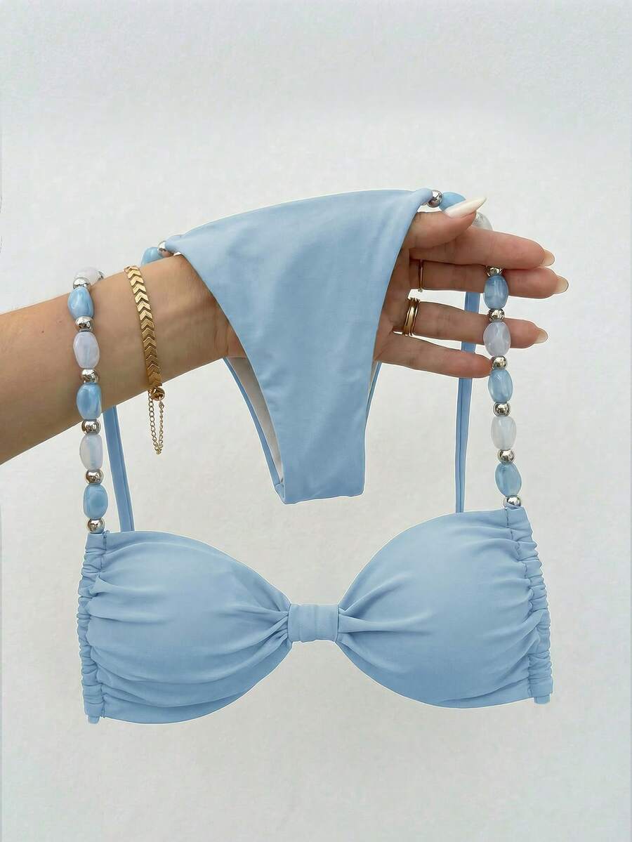 Women's green halter neck bikini set featuring color-block beaded shoulder straps, back tie detail, and high cut bottoms.