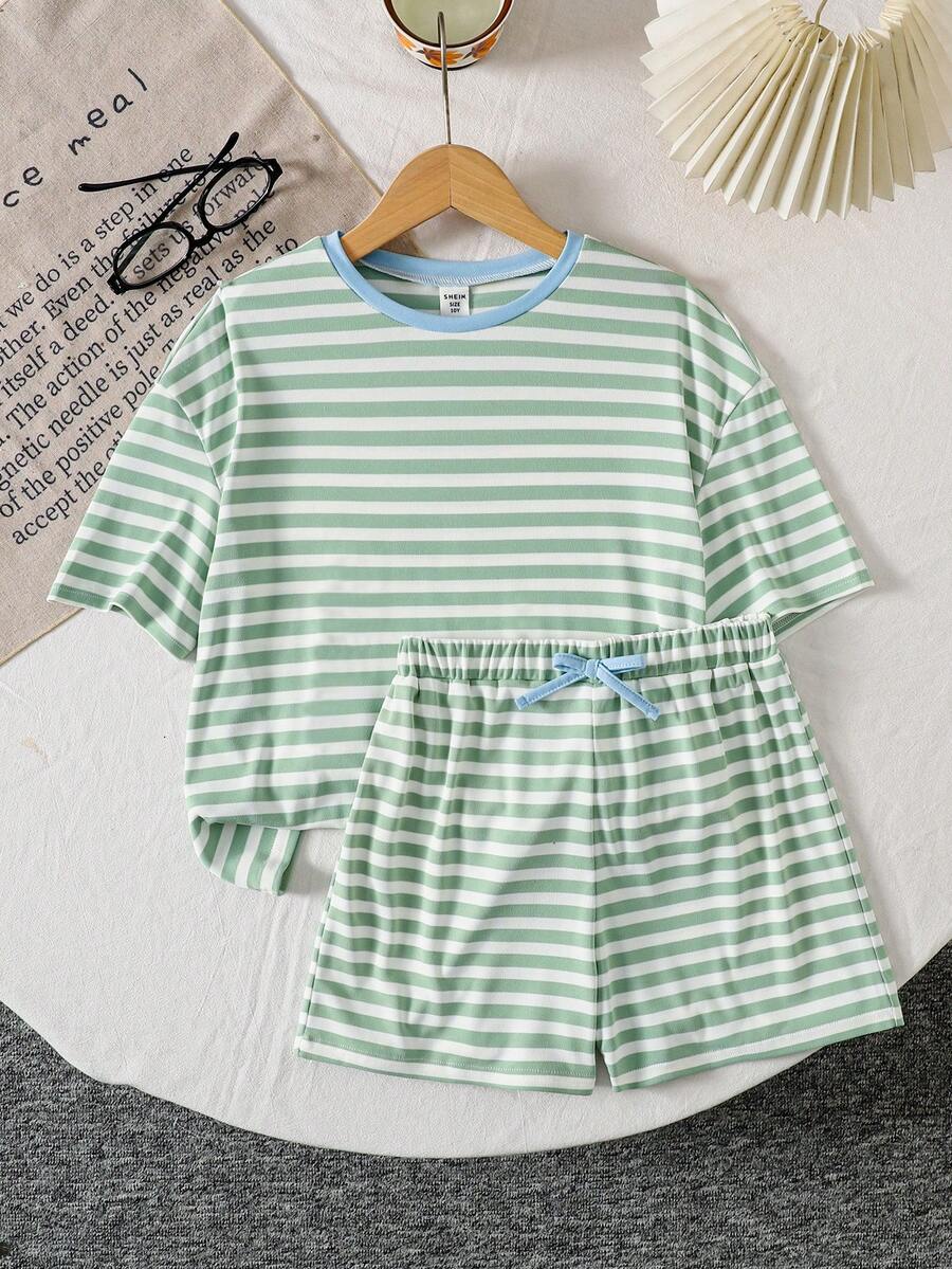 Tween girl wearing a black and white striped drop-shoulder crew neck t-shirt with bow embroidery paired with matching tie-waist shorts.
