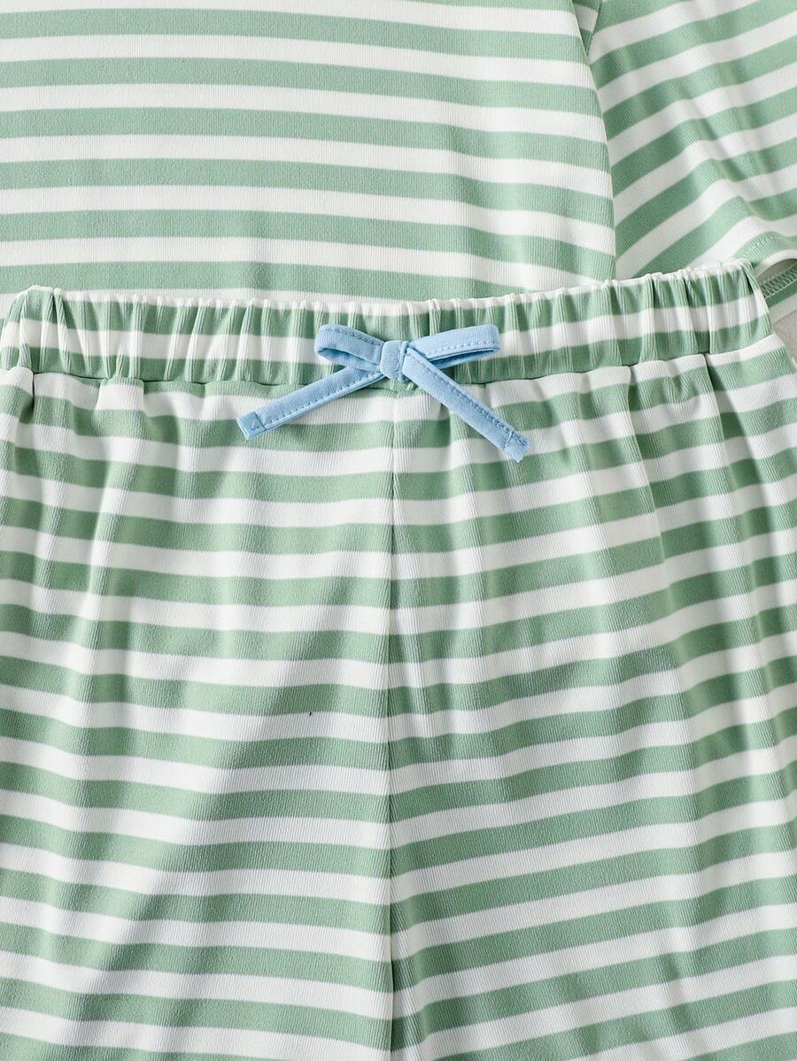 Tween girl wearing a black and white striped drop-shoulder crew neck t-shirt with bow embroidery paired with matching tie-waist shorts.