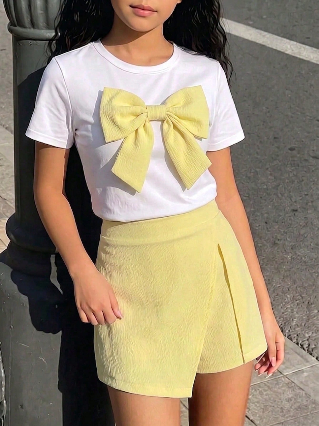 Tween girls 2-piece blue outfit featuring a short sleeve round neck t-shirt with a bow front detail and an asymmetric wrap skort.