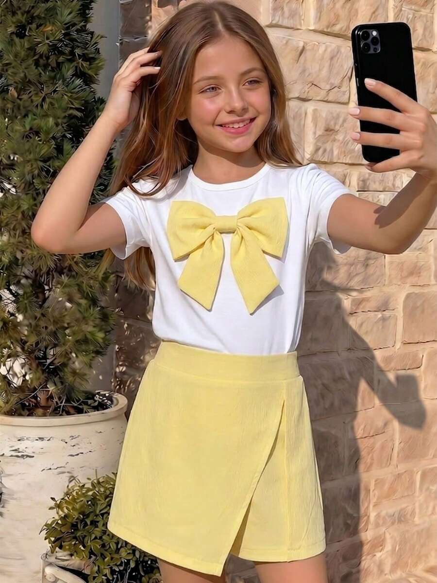 Tween girls 2-piece blue outfit featuring a short sleeve round neck t-shirt with a bow front detail and an asymmetric wrap skort.