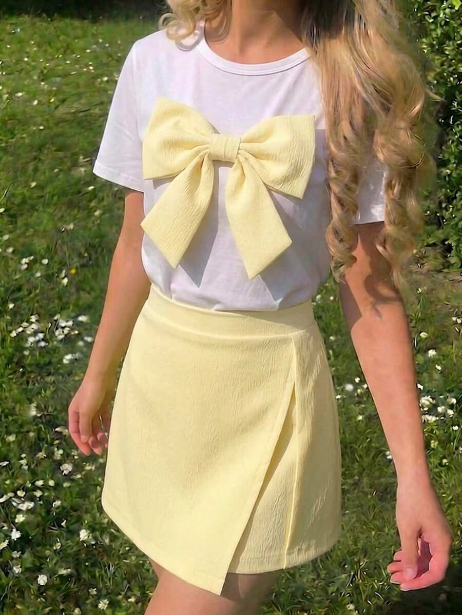 Tween girls 2-piece blue outfit featuring a short sleeve round neck t-shirt with a bow front detail and an asymmetric wrap skort.