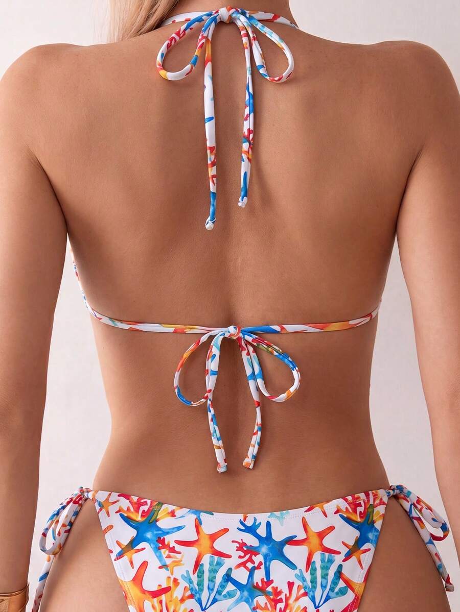 Women's black two-piece bikini set featuring a halter neck with a colorful sun pendant, triangle cups, and high-cut tie-side bottoms.