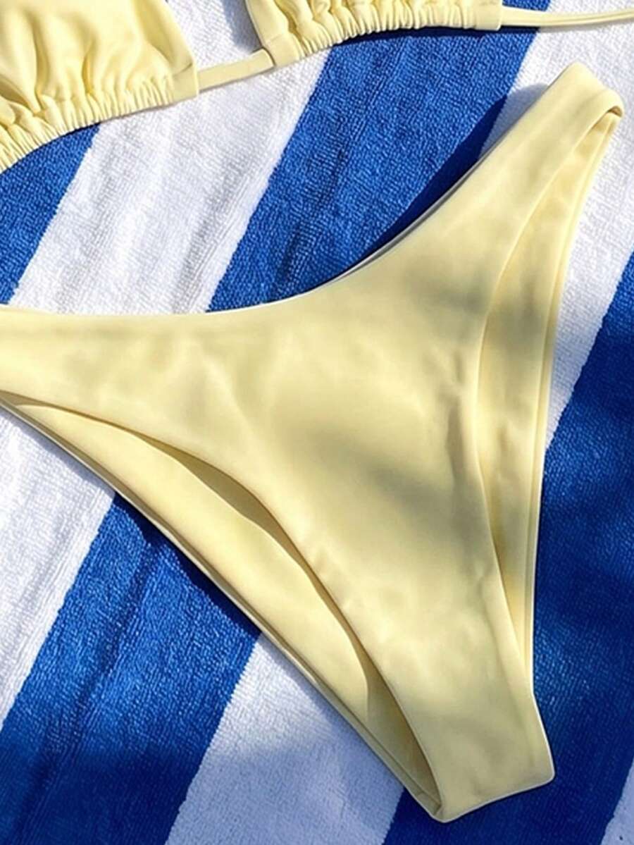 Women's two-piece halter bikini set featuring high cut thong bottoms and removable padding