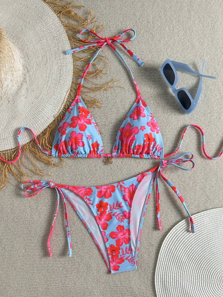 Women's black two-piece bikini set featuring a halter neck with a colorful sun pendant, triangle cups, and high-cut tie-side bottoms.