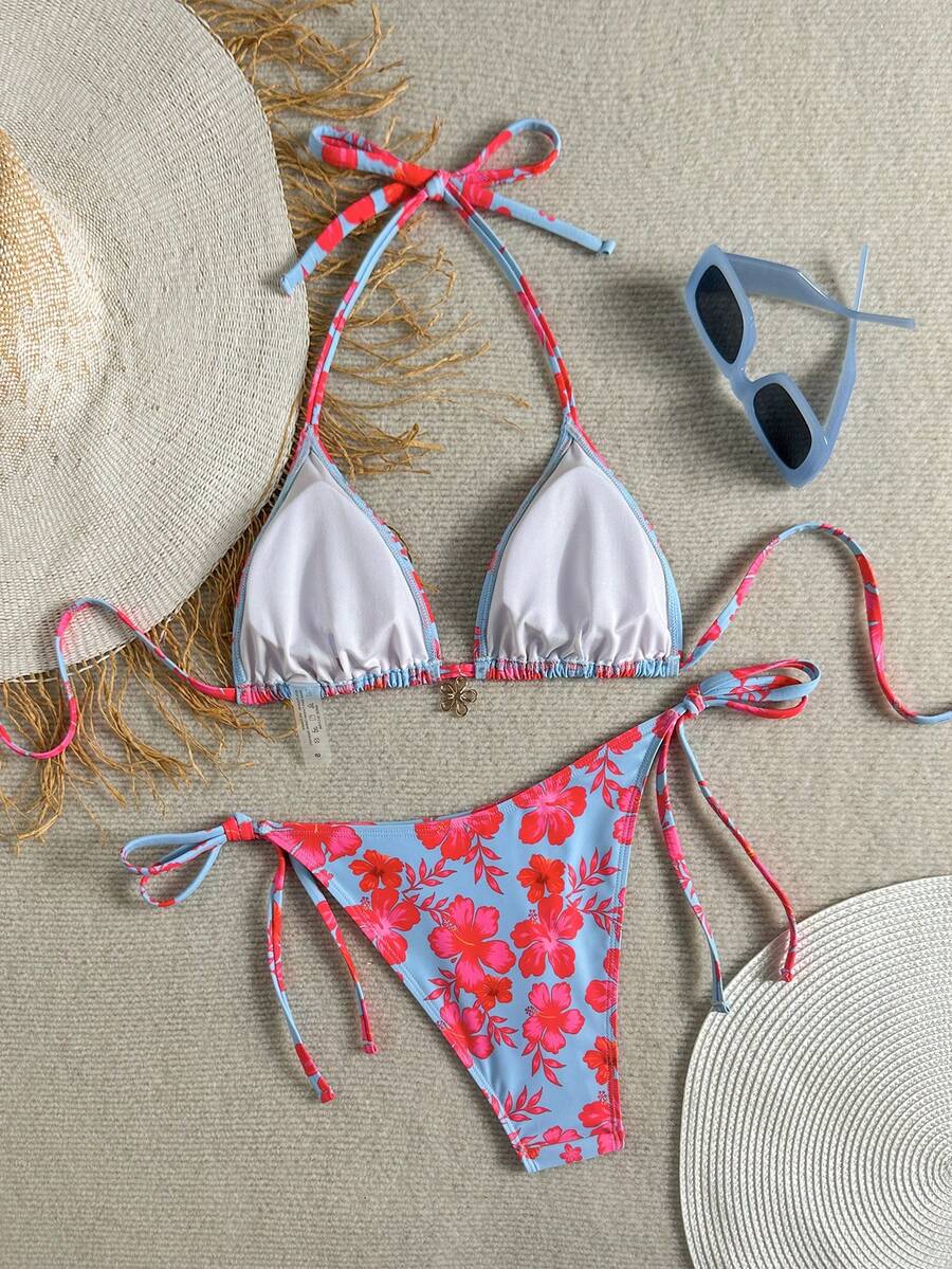 Women's black two-piece bikini set featuring a halter neck with a colorful sun pendant, triangle cups, and high-cut tie-side bottoms.