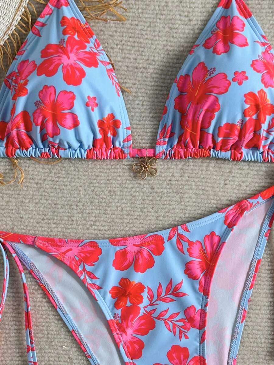 Women's black two-piece bikini set featuring a halter neck with a colorful sun pendant, triangle cups, and high-cut tie-side bottoms.