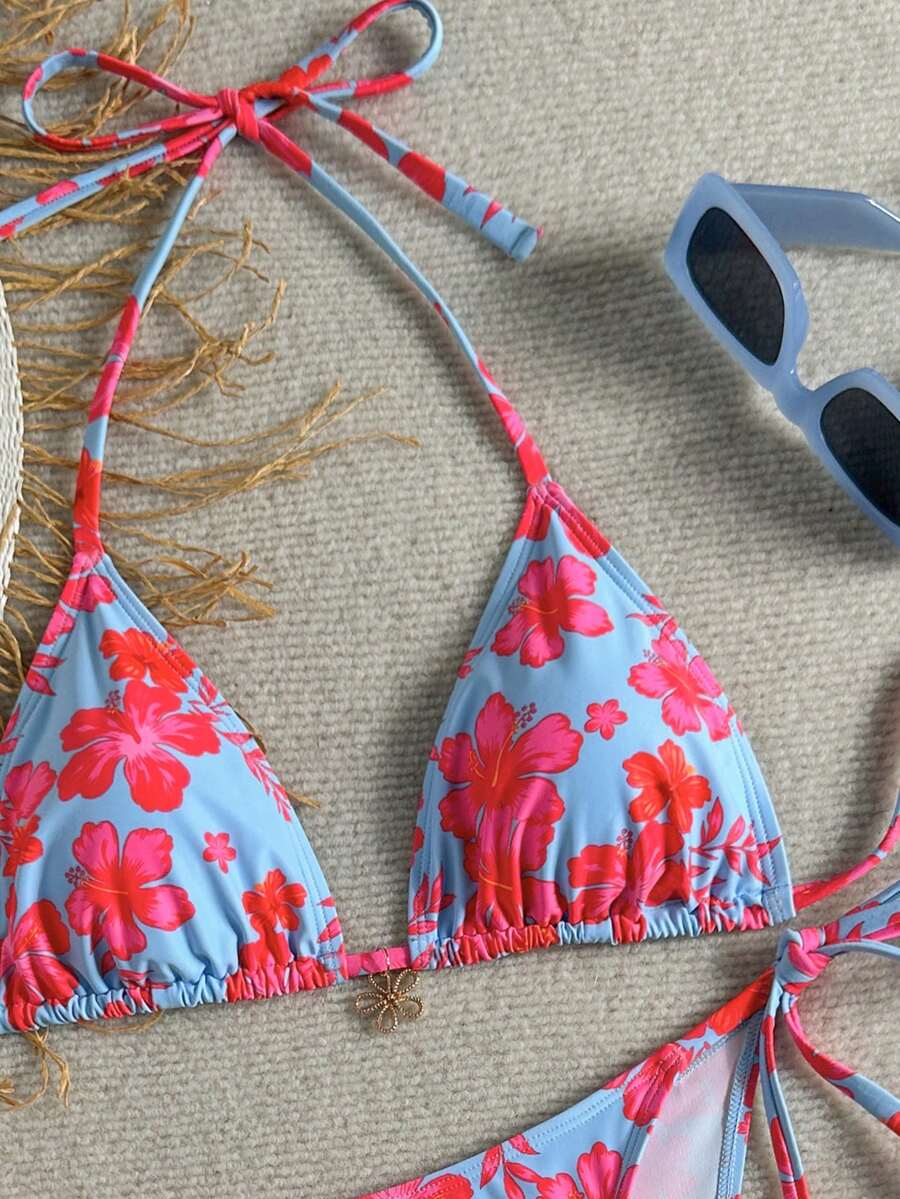 Women's black two-piece bikini set featuring a halter neck with a colorful sun pendant, triangle cups, and high-cut tie-side bottoms.