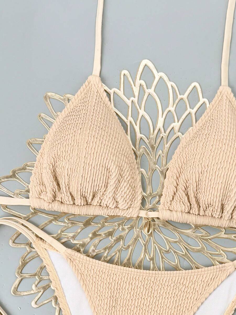 Women's black two-piece bikini set featuring a halter neck with a colorful sun pendant, triangle cups, and high-cut tie-side bottoms.