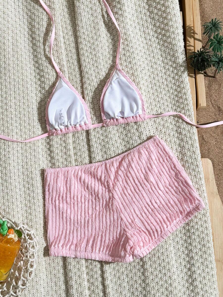 Women's apricot two-piece swimsuit set with a halter tie-back top and matching high stretch shorts.