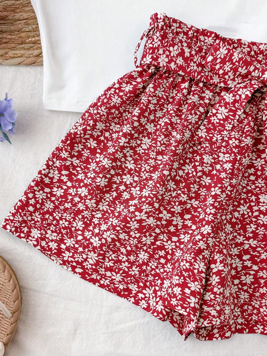 Tween girl summer two-piece outfit featuring a white scoop neck tank top and green ditsy floral print paperbag waist shorts with belt.