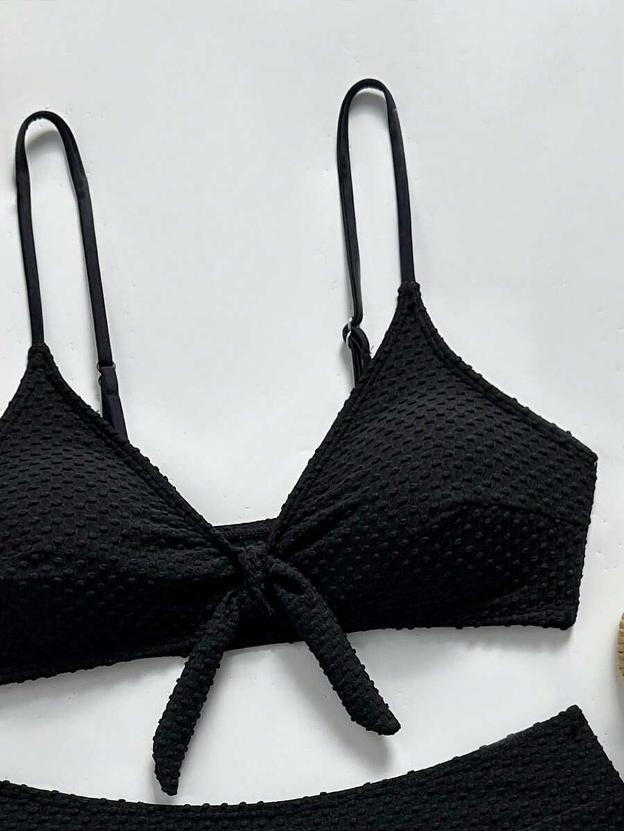 Women's black 2-piece high waist bikini swimsuit set featuring spaghetti straps, criss-cross knot details, wireless bra with removable padding, and high-stretch fabric.