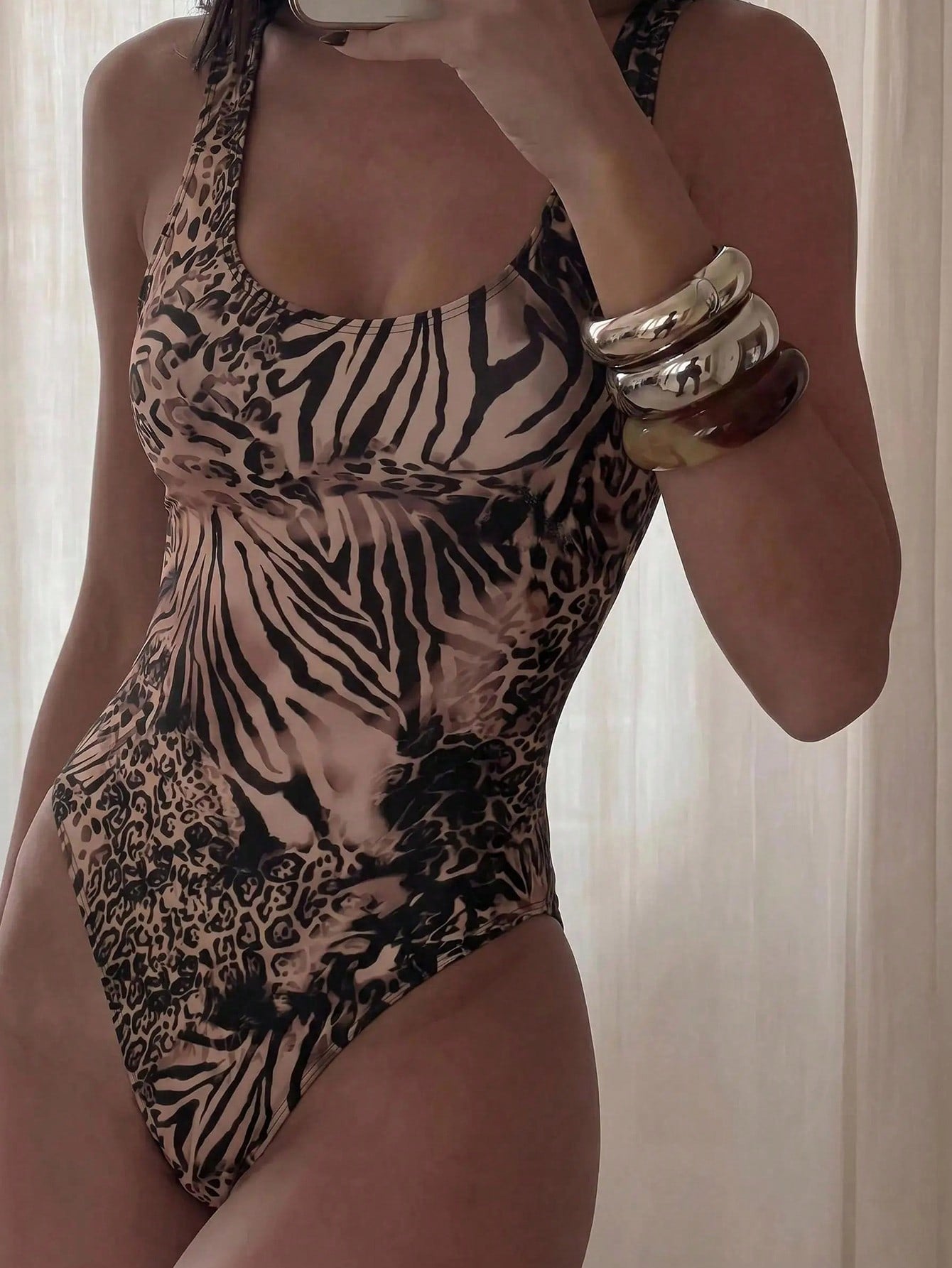 Women's solid color one-piece swimsuit featuring a backless scoop neck design and high cut fit