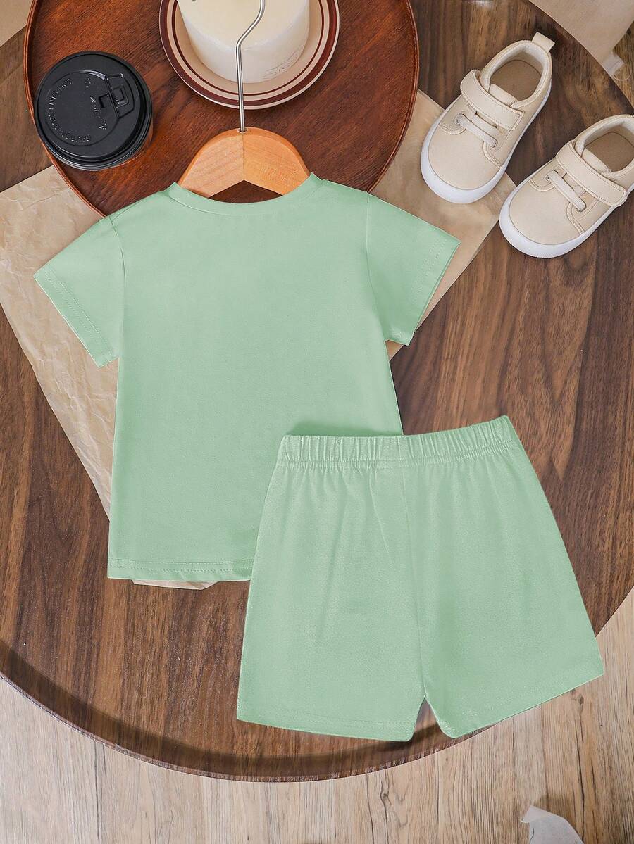Tween girls two-piece green summer outfit featuring a fruit print short sleeve round neck t-shirt and matching track shorts with pockets.