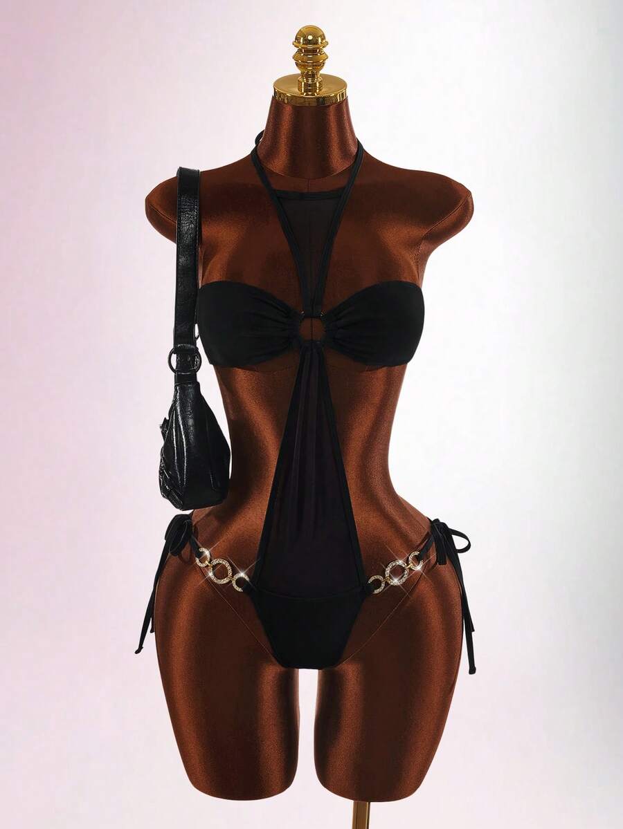 Women wearing a black cut-out one-piece swimsuit featuring a halter neck with metal detail and backless design for summer beachwear.