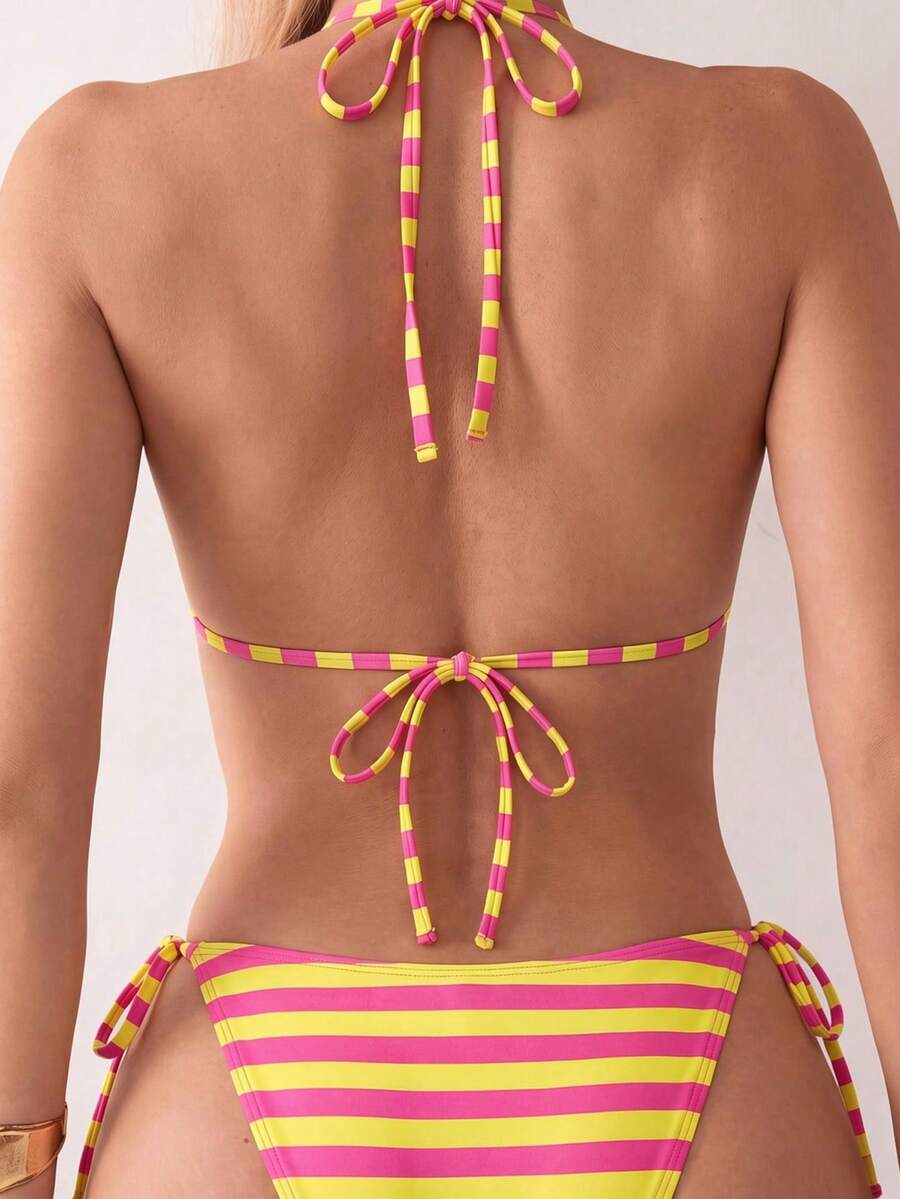 Women's black two-piece bikini set featuring a halter neck with a colorful sun pendant, triangle cups, and high-cut tie-side bottoms.