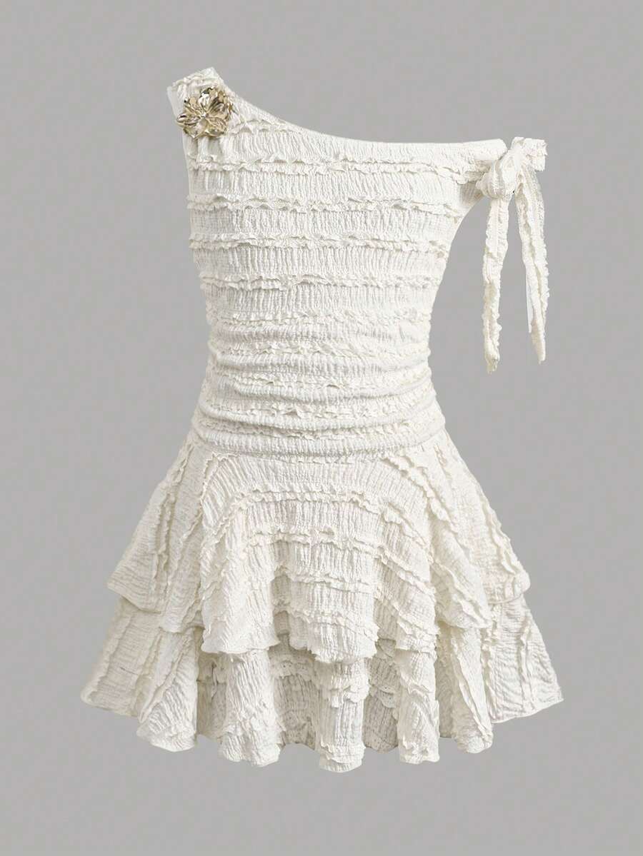 Tween girl wearing an apricot asymmetrical tiered sleeveless party dress with an A-line silhouette.