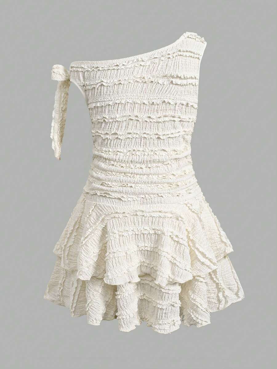 Tween girl wearing an apricot asymmetrical tiered sleeveless party dress with an A-line silhouette.