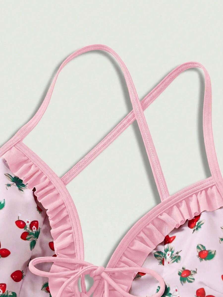 Women's strawberry print one-piece swimsuit featuring ruffle details, front-tie design, backless criss-cross straps, and triangle wireless cups.