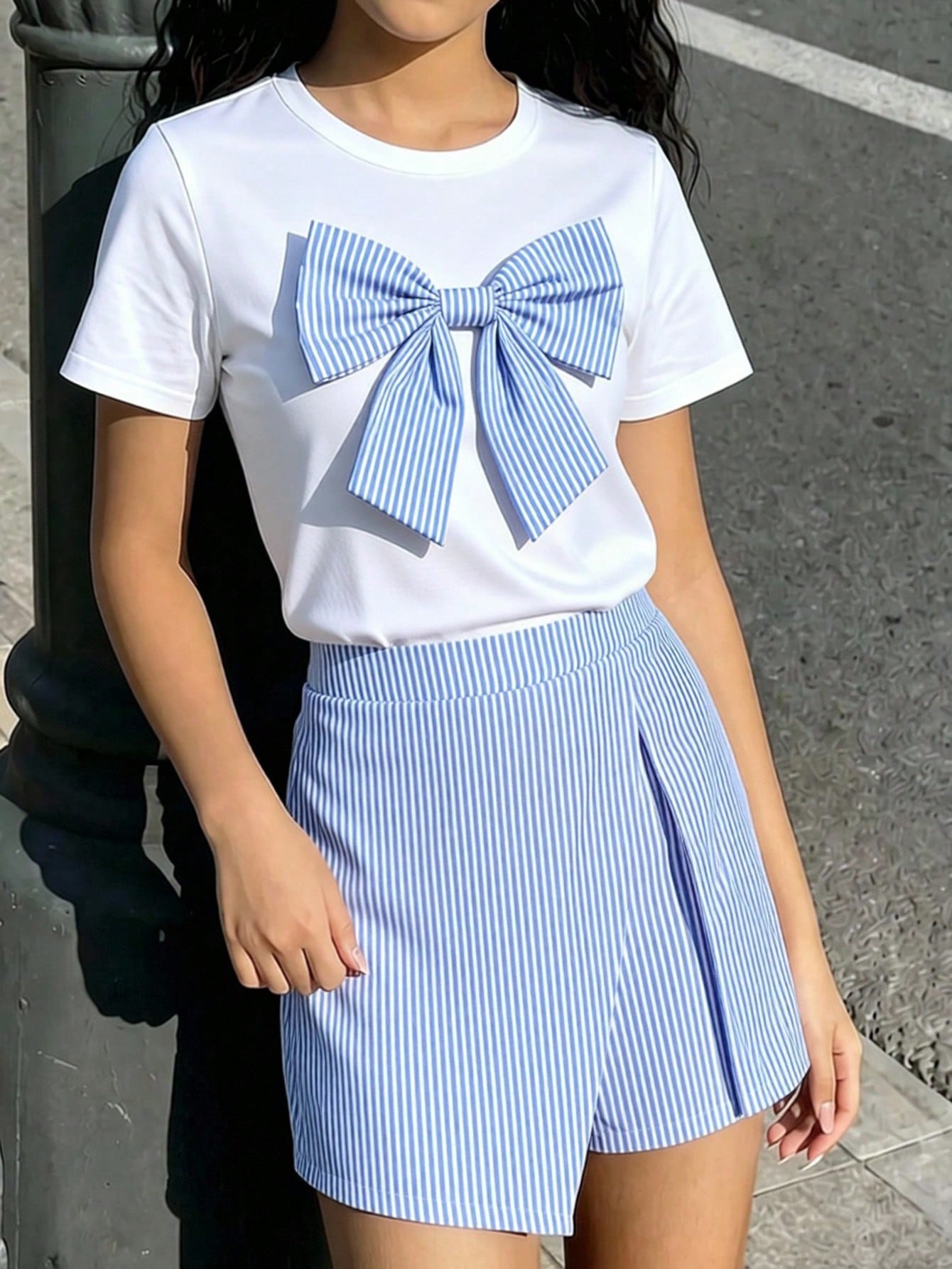 Tween girls 2-piece blue outfit featuring a short sleeve round neck t-shirt with a bow front detail and an asymmetric wrap skort.