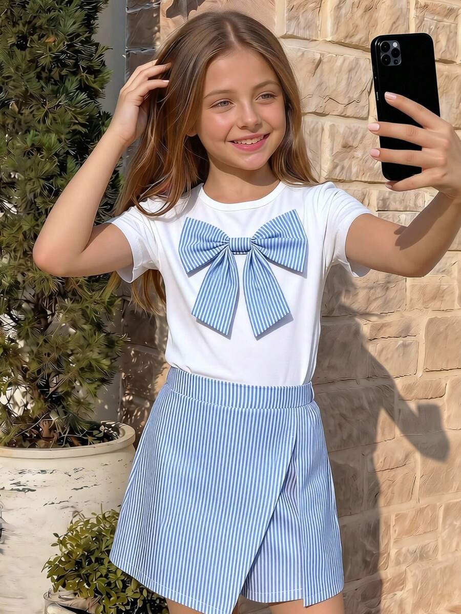 Tween girls 2-piece blue outfit featuring a short sleeve round neck t-shirt with a bow front detail and an asymmetric wrap skort.