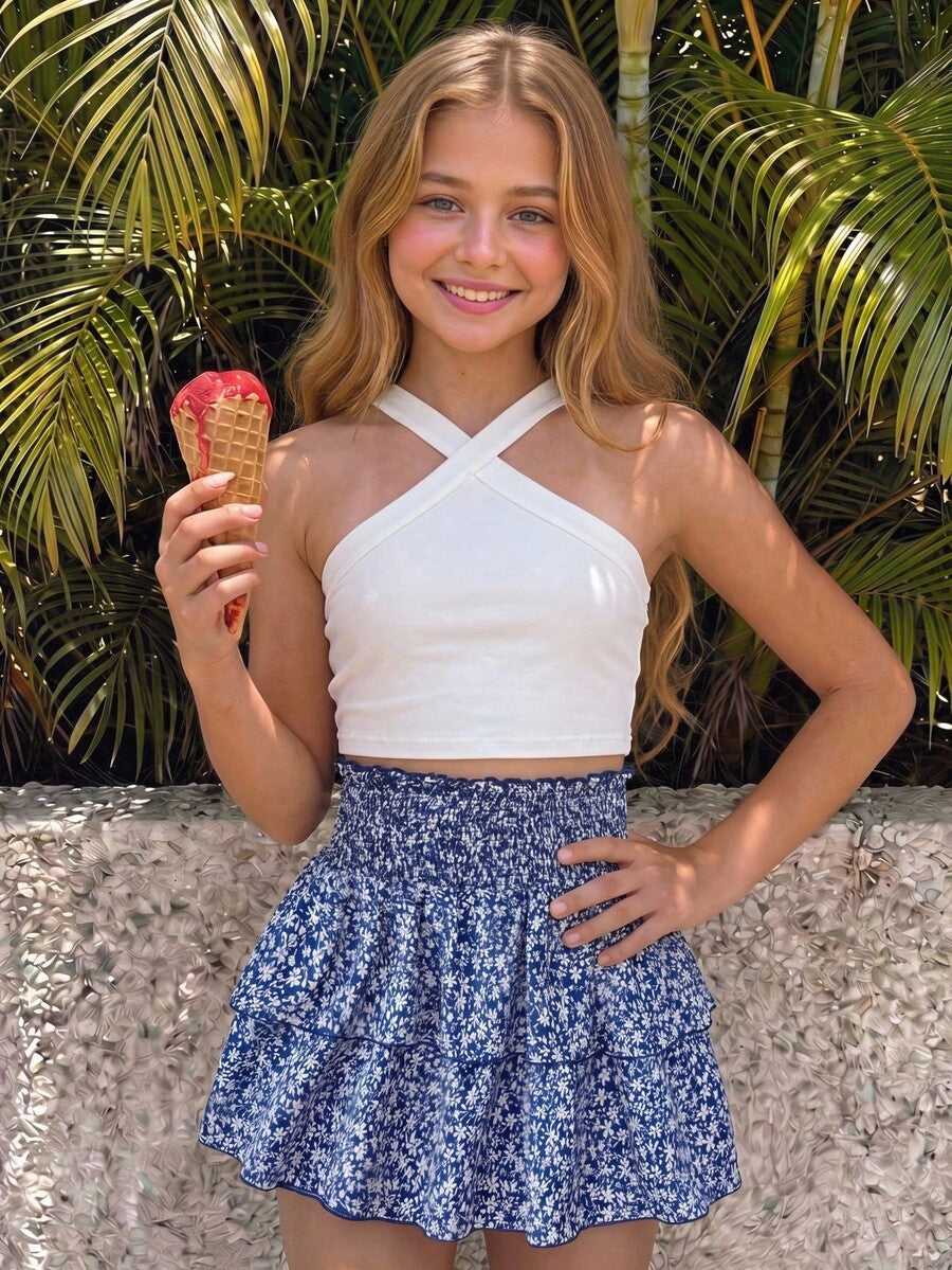 Tween girls blue and white 2-piece set with a striped halter neck vest top and a floral high-waist tiered paperbag skirt.