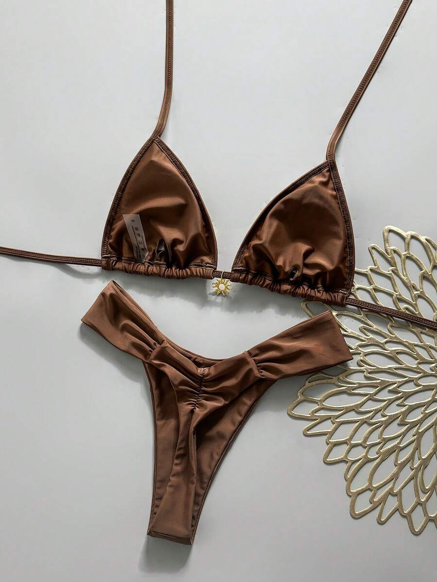 Women's 2-piece triangle cup bikini set in solid color featuring woven pearl shell decoration, halter neckline, and high-waist side-tie ruched bottoms.