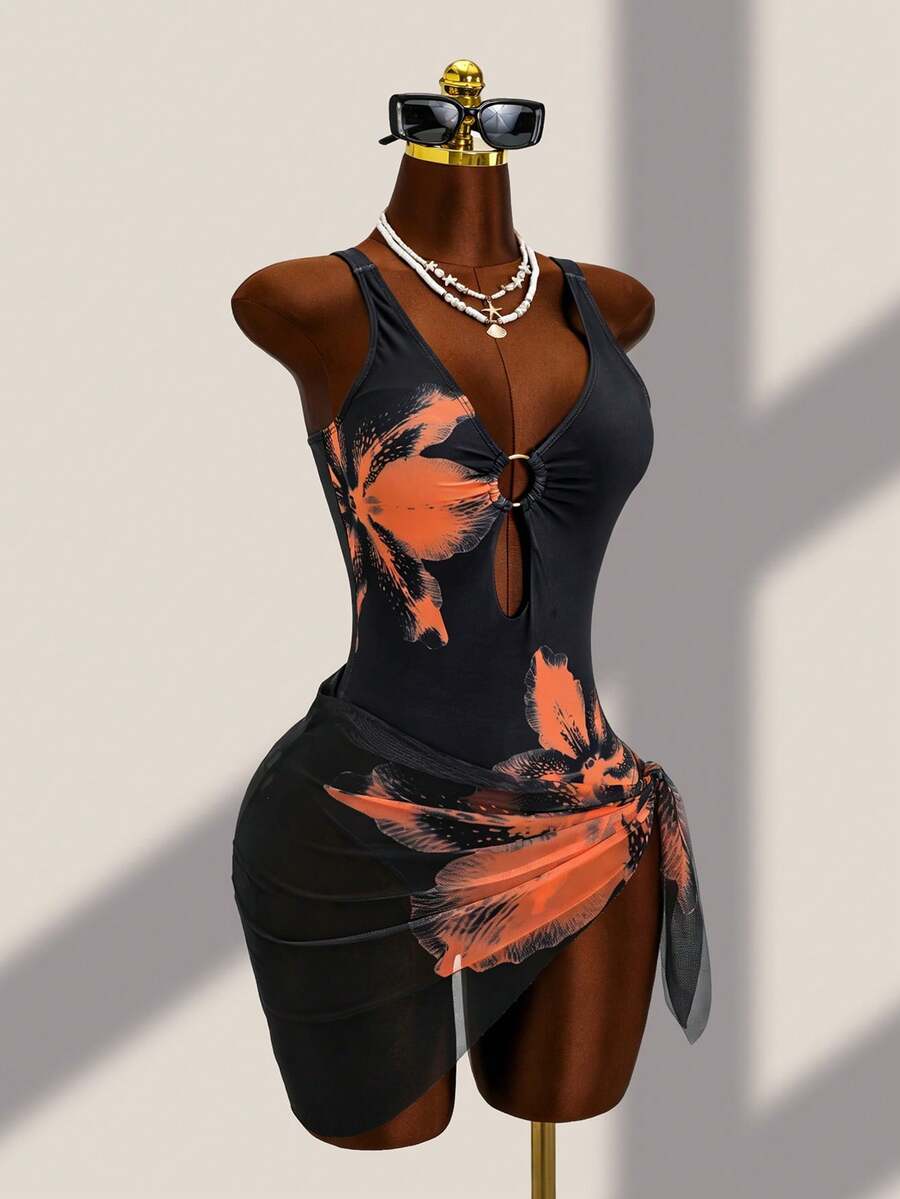 Women's black floral print plunge neck one-piece swimsuit featuring cut-out detail paired with a matching knee-length mesh cover-up skirt