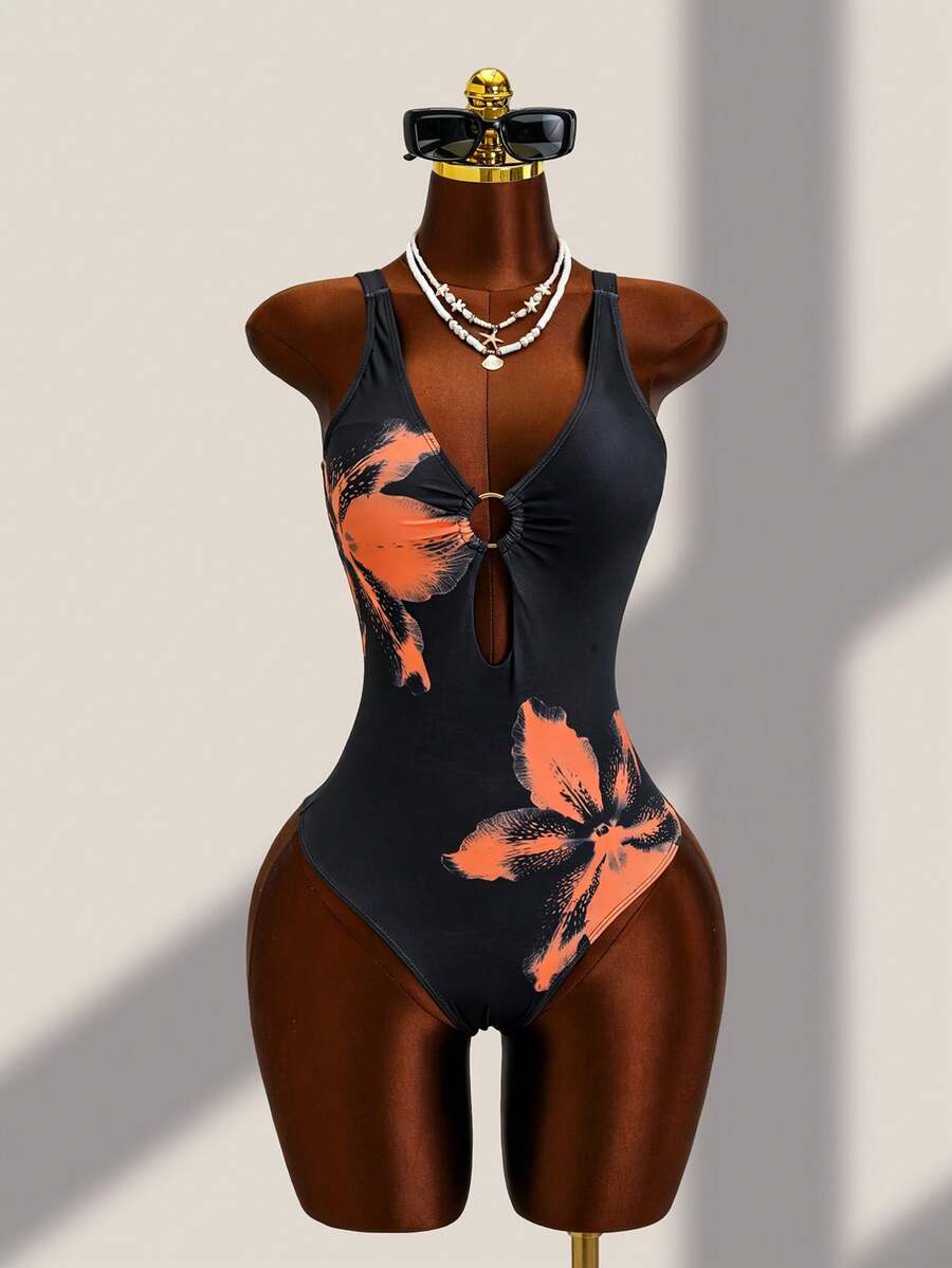 Women's black floral print plunge neck one-piece swimsuit featuring cut-out detail paired with a matching knee-length mesh cover-up skirt