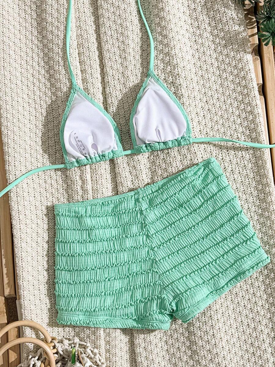 Women's apricot two-piece swimsuit set with a halter tie-back top and matching high stretch shorts.