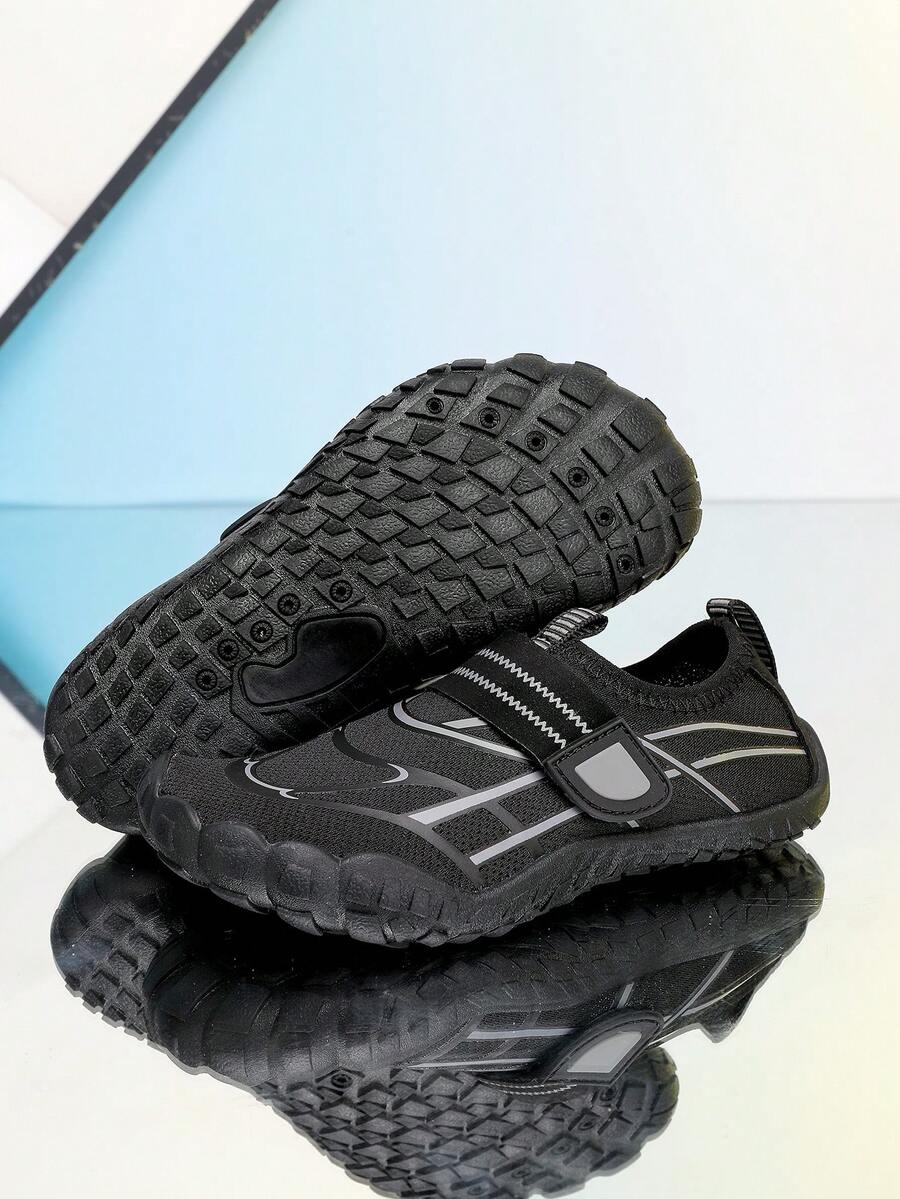 Black kids water shoes with graphic pattern, fabric upper, hook and loop closure, and non-slip rubber outsole for boys and girls.