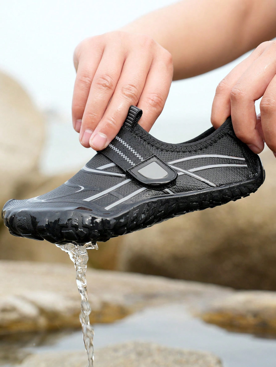 Black kids water shoes with graphic pattern, fabric upper, hook and loop closure, and non-slip rubber outsole for boys and girls.