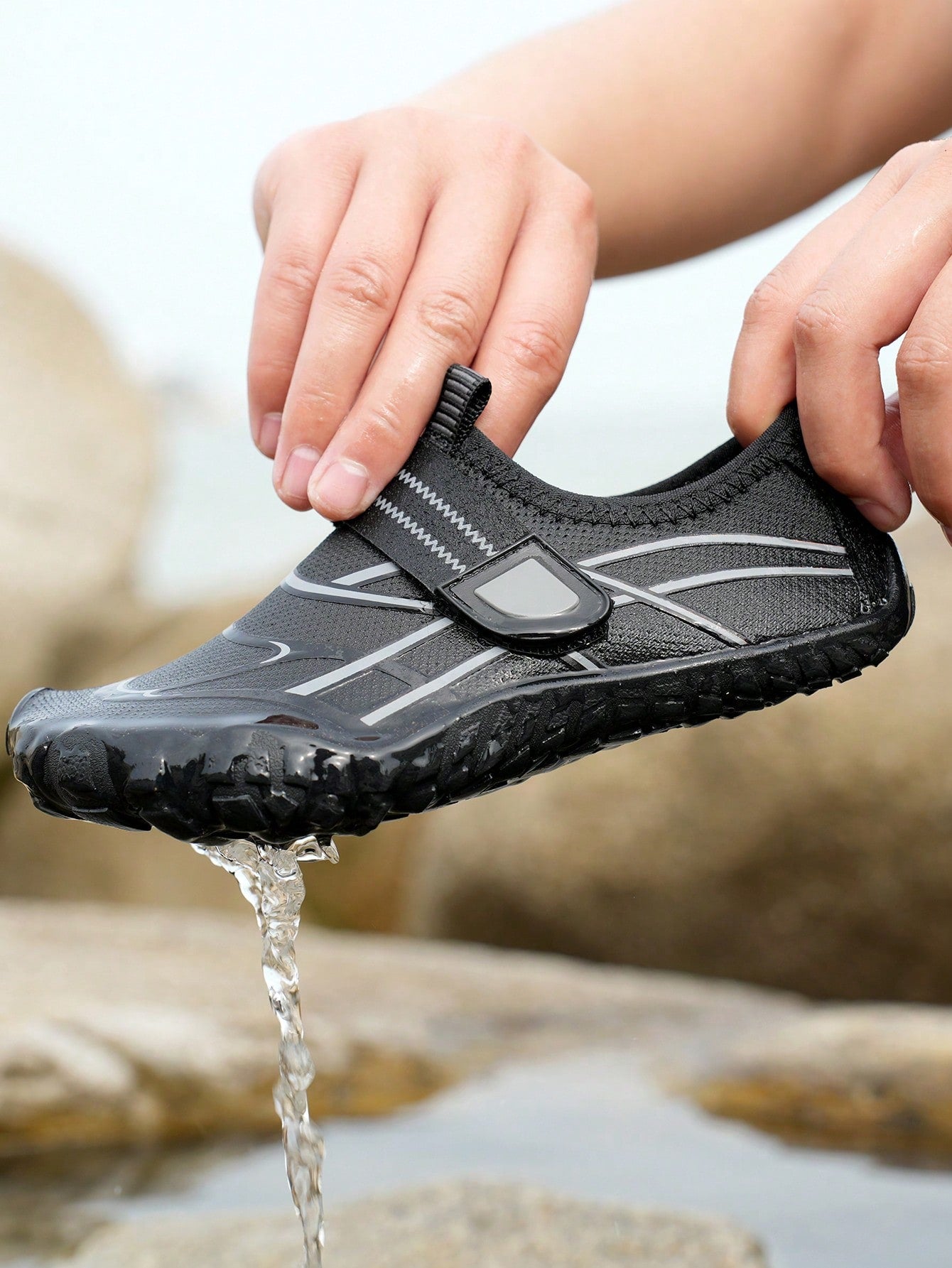 Black kids water shoes with graphic pattern, fabric upper, hook and loop closure, and non-slip rubber outsole for boys and girls.