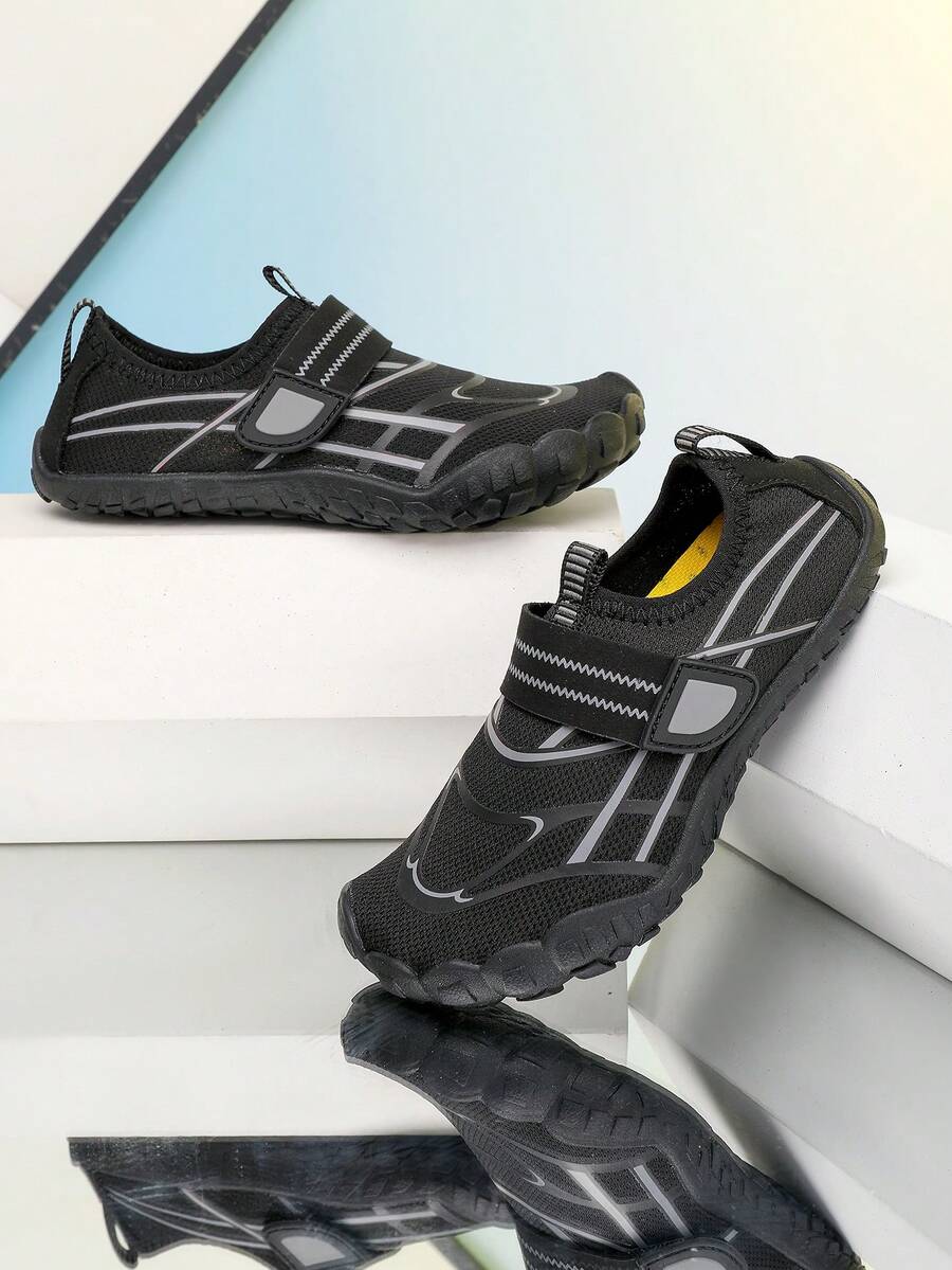 Black kids water shoes with graphic pattern, fabric upper, hook and loop closure, and non-slip rubber outsole for boys and girls.