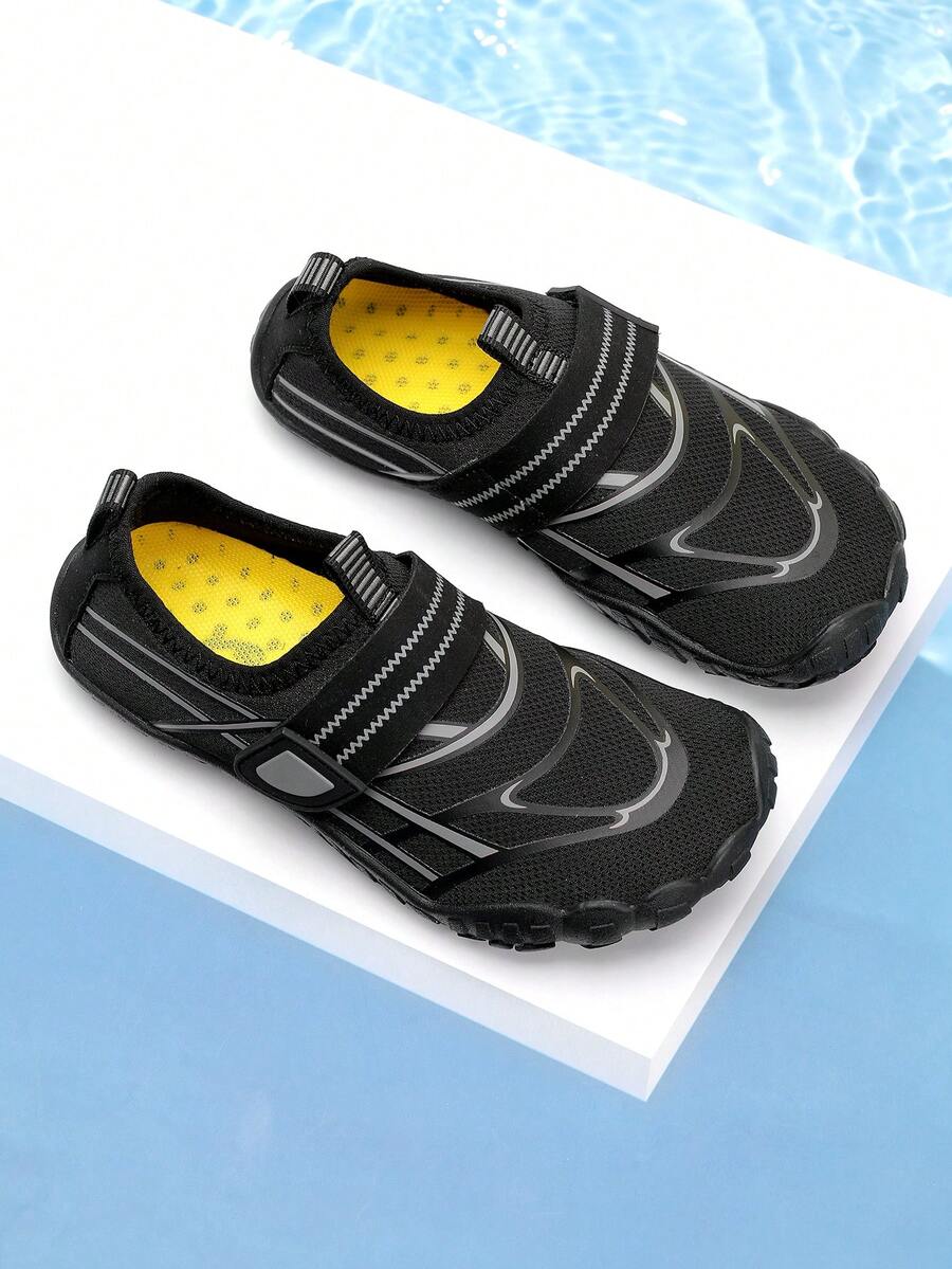 Black kids water shoes with graphic pattern, fabric upper, hook and loop closure, and non-slip rubber outsole for boys and girls.