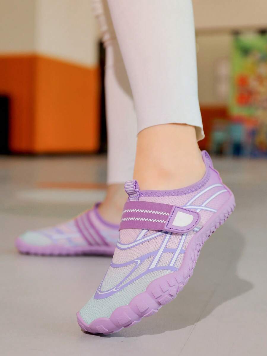 Black kids water shoes with graphic pattern, fabric upper, hook and loop closure, and non-slip rubber outsole for boys and girls.
