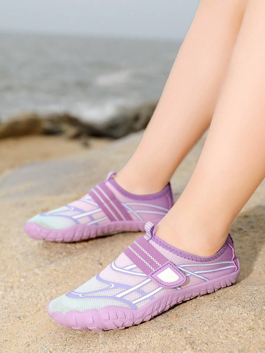 Black kids water shoes with graphic pattern, fabric upper, hook and loop closure, and non-slip rubber outsole for boys and girls.