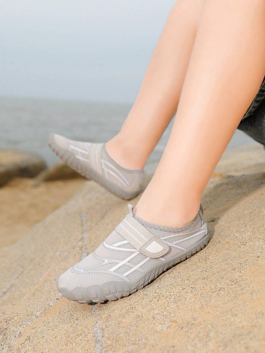 Black kids water shoes with graphic pattern, fabric upper, hook and loop closure, and non-slip rubber outsole for boys and girls.