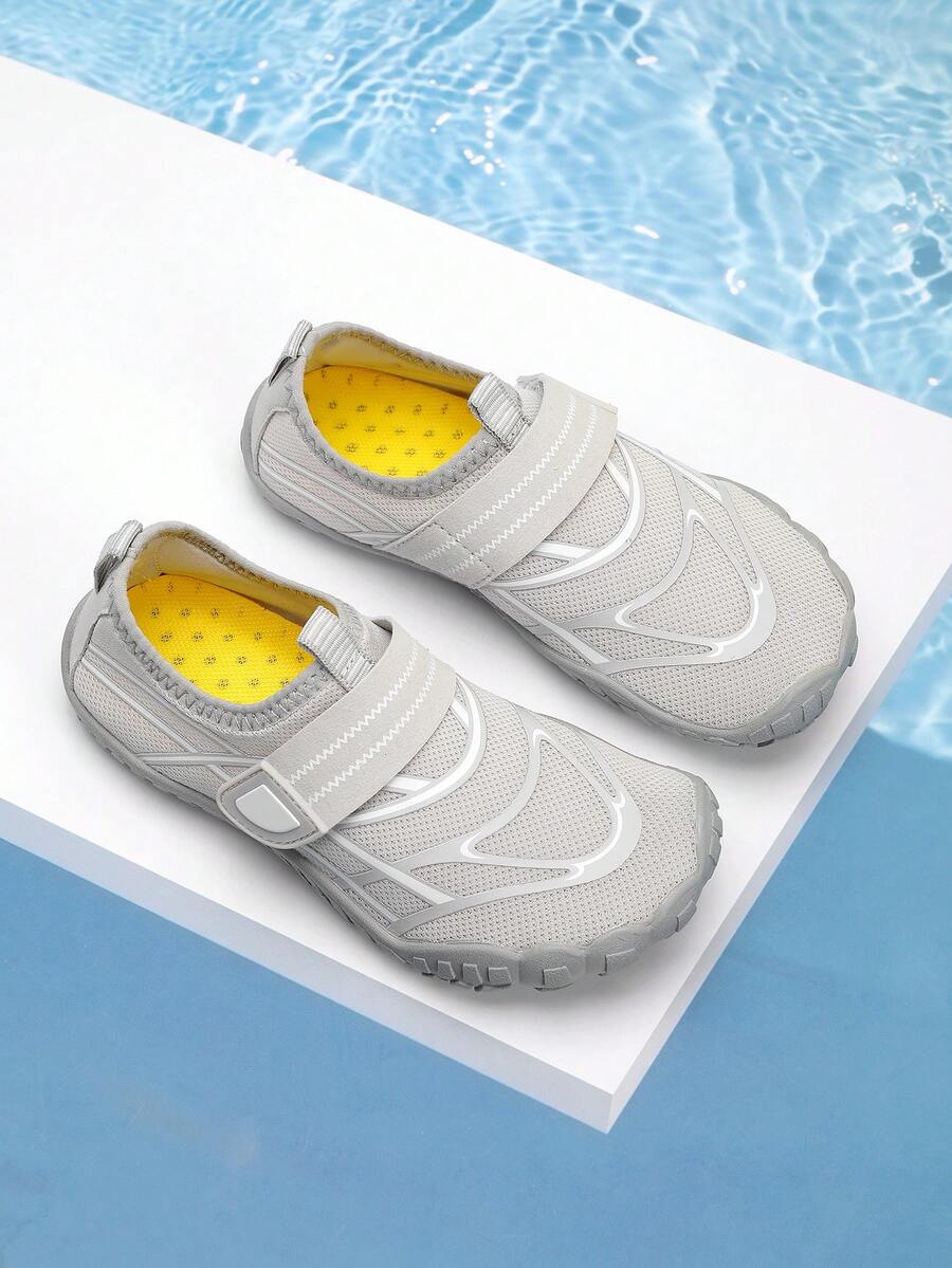 Black kids water shoes with graphic pattern, fabric upper, hook and loop closure, and non-slip rubber outsole for boys and girls.