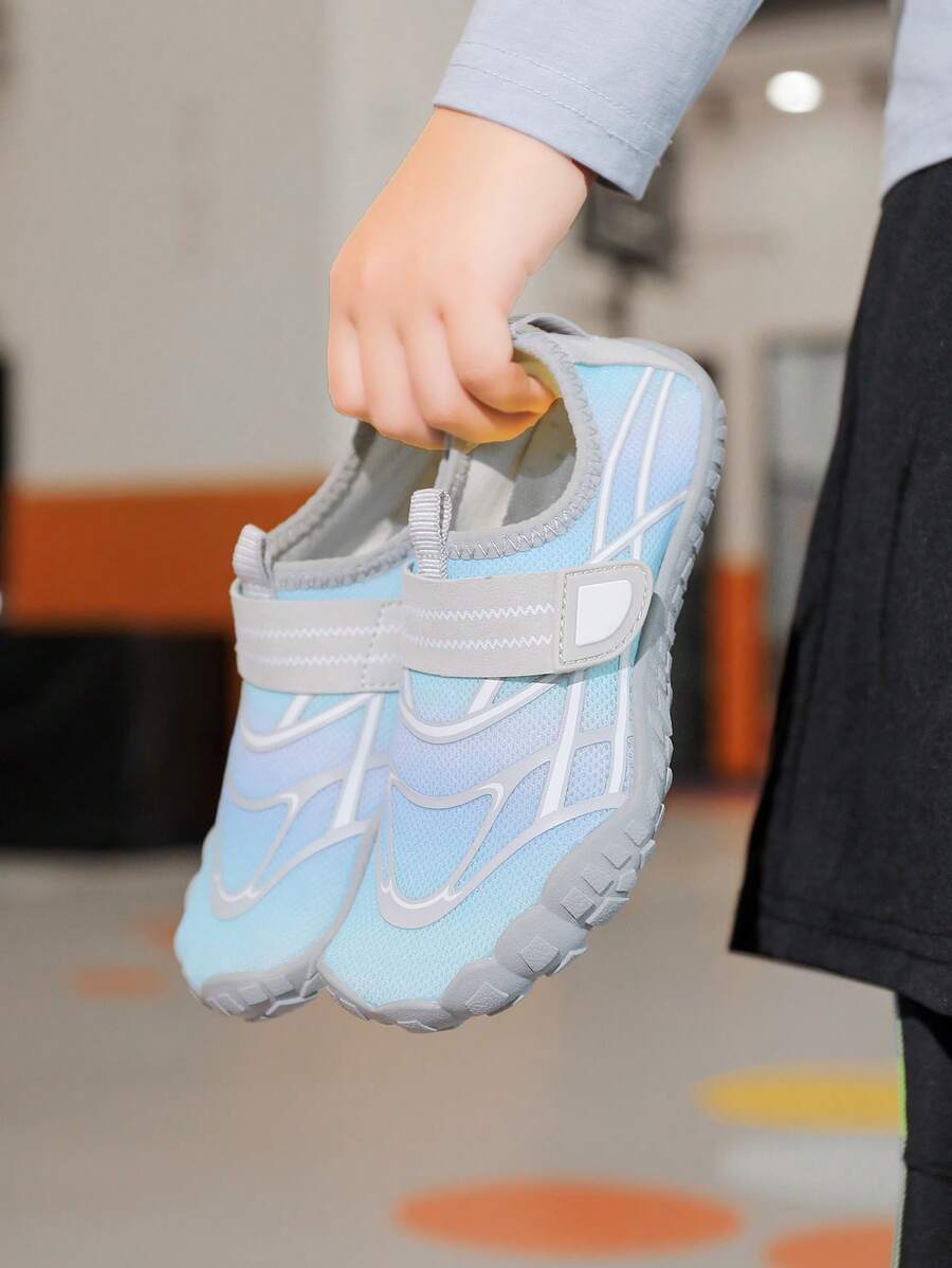 Black kids water shoes with graphic pattern, fabric upper, hook and loop closure, and non-slip rubber outsole for boys and girls.