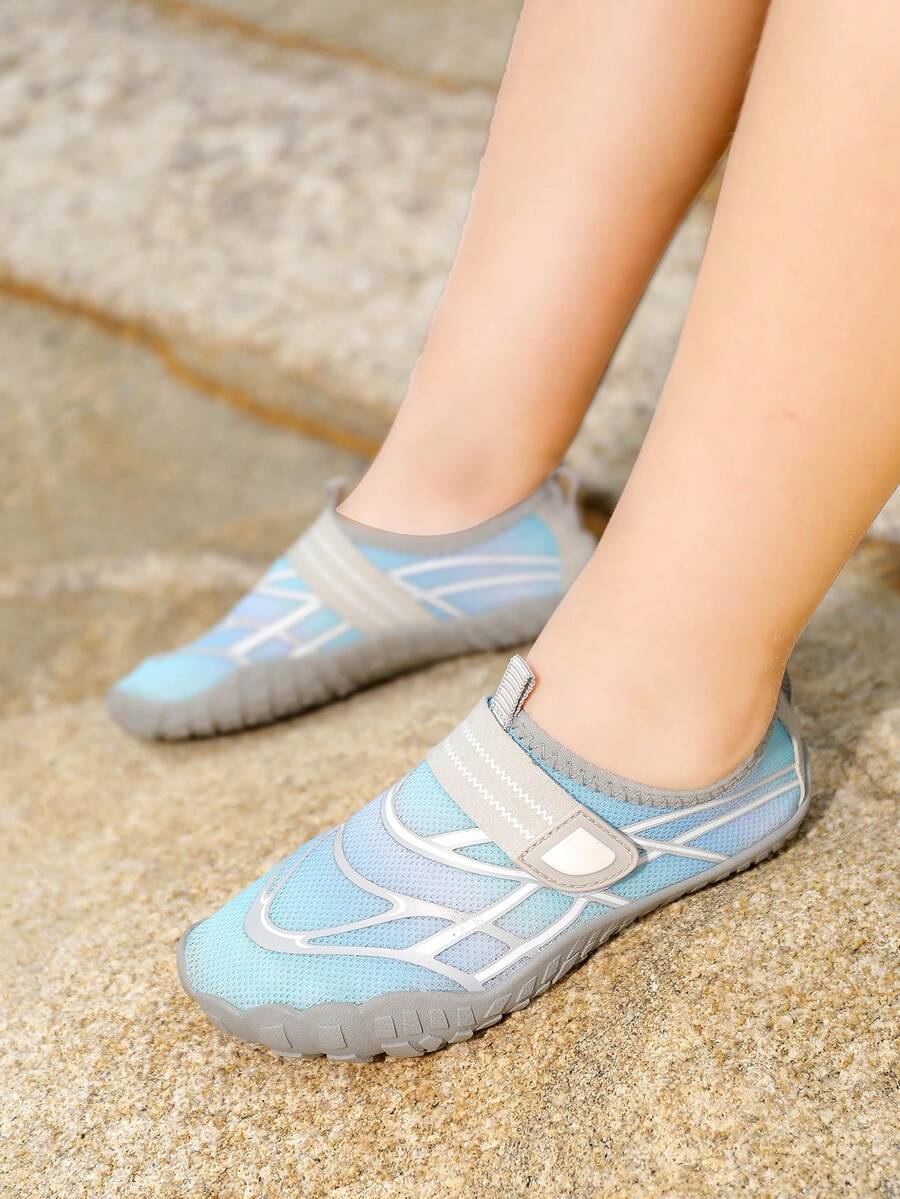 Black kids water shoes with graphic pattern, fabric upper, hook and loop closure, and non-slip rubber outsole for boys and girls.