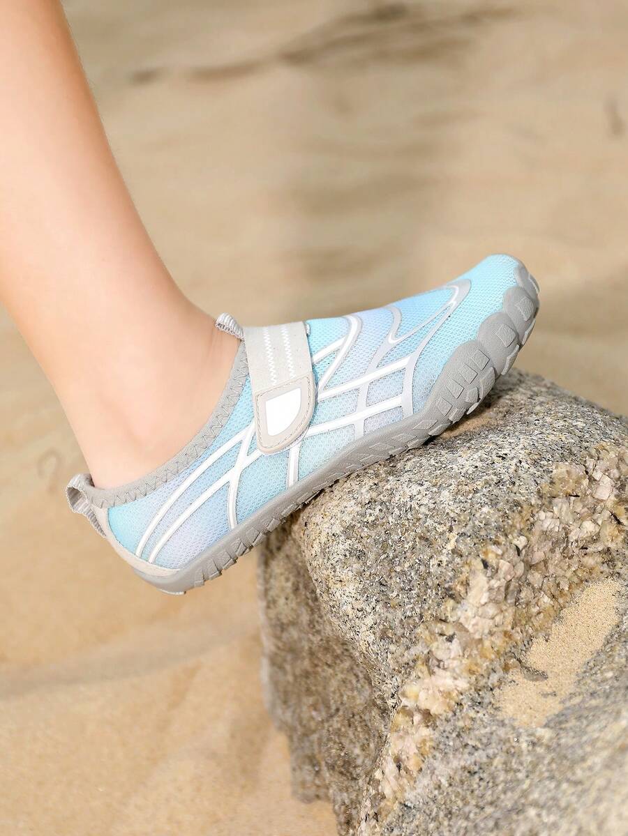 Black kids water shoes with graphic pattern, fabric upper, hook and loop closure, and non-slip rubber outsole for boys and girls.